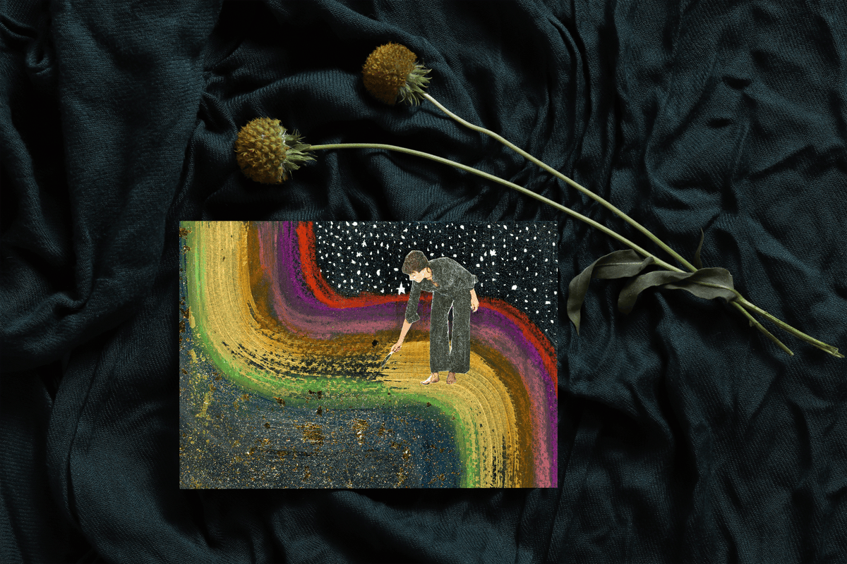 Art print sitting on draped teal fabric with dried flowers. Art print shows woman standing on a rainbow with a paintbrush in a black glittery sky.